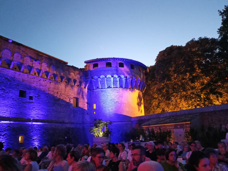 il pubblico a una serata teatrale nel giardino della rocca di ravaldino